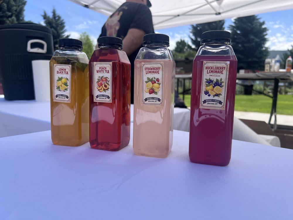 Four bottled House of Hogs drinks: lemon black tea, peach white tea, strawberry lemonade, and huckleberry lemonade